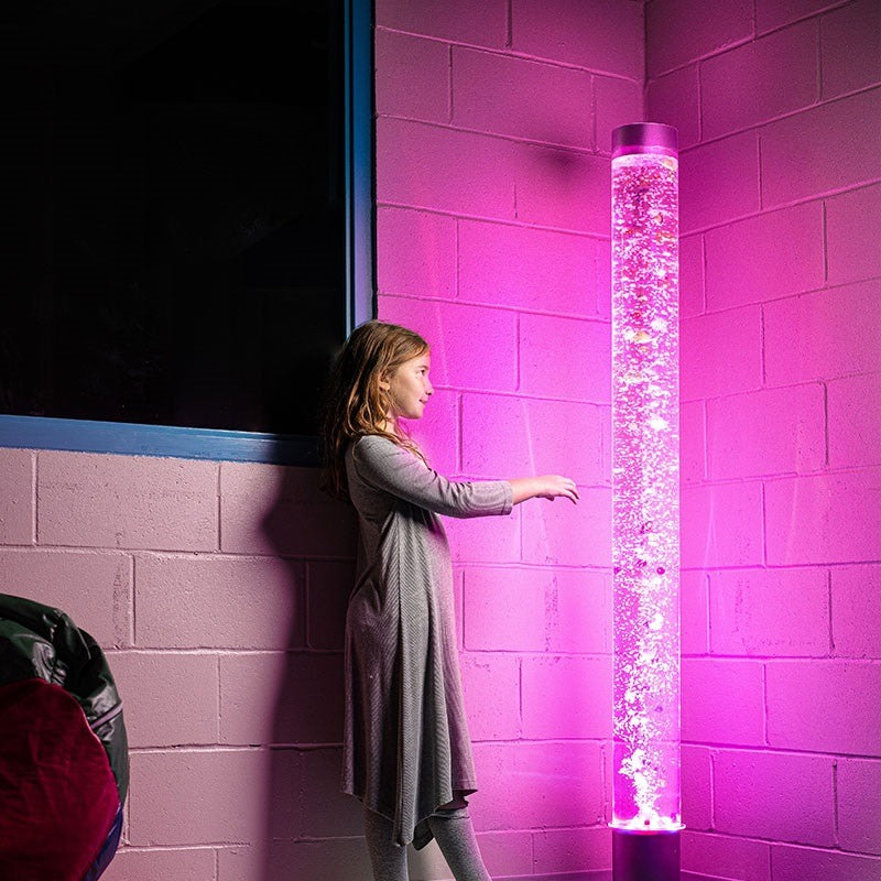 Girl is standing in front of the Bubble Tube Column Water Feature